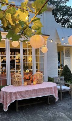 a table that has some lights on it in front of a building with many windows