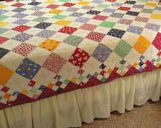 a bed with a colorful quilt on top of it