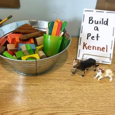 a bowl filled with lots of toys next to a sign that says build a pet kennel