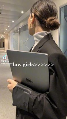 a woman holding a laptop computer in an empty room with the words law girls on it