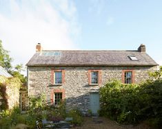 an old stone house is surrounded by greenery