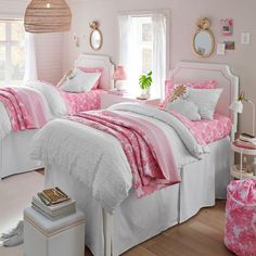 two beds with pink and white comforters in a bedroom