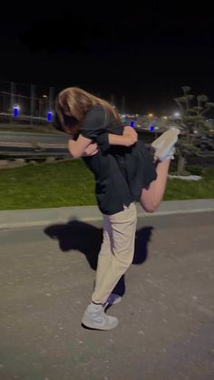 a man is carrying another person on his back in the middle of an empty parking lot