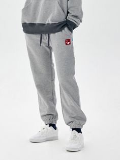 This is an trendy jogger pants in an oversized silhouette that you can wear comfortably. These are a comfortable and wearable item that is good to match with various items.  - Cotton material- Banding and string on waist- Graphic embroidery design on the front- Sturdy hemline at the bottom as a refined touch Casual Gray Joggers With Elastic Cuffs, Gray Sweats With Elastic Waistband For Streetwear, Casual Gray Joggers With Ribbed Waistband, Gray Casual Sweats For Leisure, Gray Sweats With Elastic Waistband For Jogging, Gray Joggers With Elastic Waistband, Gray Sweats With Pockets For Streetwear, Casual Gray Sweatpants With Elastic Waistband, Gray Athleisure Joggers With Elastic Cuffs