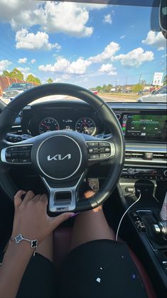 a woman driving a car with her hands on the steering wheel