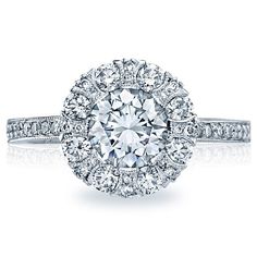 a diamond engagement ring with two rows of diamonds on the band and an oval center stone surrounded