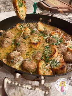 a skillet filled with meatballs and cheese being sprinkled on top of it