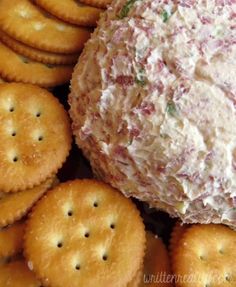 crackers are arranged around a cheese ball on a platter filled with crab salad