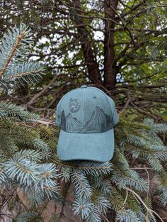 This wood burned green faux suede baseball cap would make a great addition to any nature lover's wardrobe. I hand burnt a mountain range around the entire crown of the hat with pine trees growing along it using a pyrography tool and a freehanded original design. Then, for a unique finishing touch I burnt a full moon with craters and stars in the sky above the landscape. Materials: 100% cotton Hat fits most with an adjustable buckle in the back *Disclaimer* colors may vary slightly from screen to screen Green Visor Baseball Cap For Outdoor Activities, Green Curved Brim Dad Hat For Outdoor, Green Baseball Cap For Outdoor Activities, Green Baseball Cap For Outdoor Baseball Season, Green Cap For Outdoor Activities, Adjustable Green Hats For Adventure, Green Visor Hat For Outdoor Activities, Green Adjustable Dad Hat For Outdoor Activities, Green Snapback Hat For Adventure