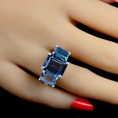 Classic Ring of London Blue Topaz. This elegant three stone ring features three London Blue in emerald cut for a total weight of 14.84 carats. Custom setting of sterling silver. Wear this gorgeous ring morning right through the day and through the evening. No changes by seller. Sizable 8. See your local jeweler for changes. MR2343 Luxury Modern Topaz Ring With Diamond Accents, Luxury Diamond Three Stone Topaz Ring, Luxury Timeless Topaz Ring With Accent Stones, Luxury Blue Topaz Open Ring, Luxury Anniversary Topaz Open Ring, Exquisite Luxury Topaz Ring For Anniversary, Luxury Topaz Timeless Jewelry, Luxury Handmade Unique Topaz Ring, Luxury Blue Topaz Jewelry With Gemstone Accents