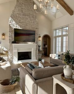 a living room filled with furniture and a flat screen tv mounted on the wall above a fireplace