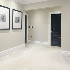 an empty room with pictures hanging on the wall and carpeted floor in front of it