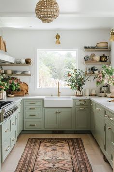 a kitchen with green cabinets and an area rug