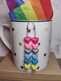 Show your genderflux pride with these beaded earrings, featuring heart-shaped pony beads representing the colors of the genderflux pride flag! Can't find your flag? Prefer a different style? Shoot us a message to inquire about a custom order! All of our earrings are nickel and lead free and sanitized before shipping to you. Fun Multicolor Heart Earrings As Gift, Genderflux Flag, Trendy Jewelry For Pride Gifts, Trendy Multicolor Dangle Heart Earrings, Trendy Multicolor Heart Dangle Earrings, Multicolor Heart Beads Earrings For Valentine's Day, Multicolor Hypoallergenic Heart Earrings, Multicolor Heart Beaded Earrings For Valentine's Day, Adjustable Multicolor Heart Earrings For Valentine's Day