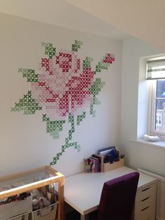 a room with a desk, chair and flower wall decal on the wall behind it