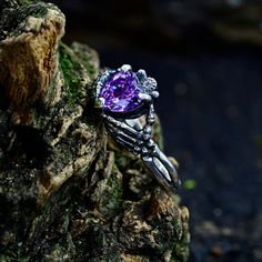 Crafted in sterling silver, this witchy engagement ring features a captivating purple stone in a nature-inspired design. Perfect as a forest promise ring, it embraces the essence of the witchy and gothic aesthetic, making it a unique and enchanting symbol of love.  Characteristics: Metal - Recycled solid sterling silver  Stone - Cubic Zirconia 7x7 mm. Finish - Oxidized. View all silver witchy rings: https://www.etsy.com/shop/TinyShinyJewel?ref=seller-platform-mcnav&section_id=44336283 Care instr Gothic Sterling Silver Crystal Ring As Gift, Gothic Sterling Silver Crystal Ring For Gift, Magical Sterling Silver Crystal Ring For Gift, Magical Promise Ring Jewelry, Mystical Sterling Silver Birthstone Rings, Sterling Silver Magical Promise Ring, Silver Amethyst Crystal Promise Ring, Gothic Sterling Silver Promise Jewelry, Anniversary Spiritual Skull Ring