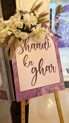 a sign that says shaadi e ghaar on it with flowers in the center