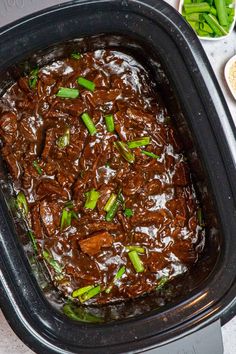 the food in the crock pot is ready to be eaten and served on the table