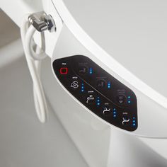 an electronic device is attached to the side of a toilet seat with buttons on it