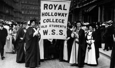 black and white photograph of people holding a sign that says royal hollowway college old students w s