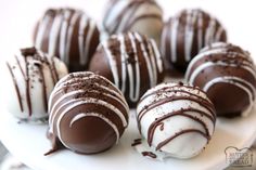 chocolate covered desserts are arranged on a white plate