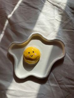 an egg shell with a smiley face painted on the side, sitting on a white sheet