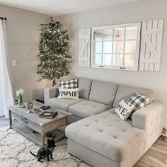 a living room with a couch, coffee table and christmas tree in the corner area