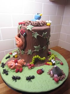 a cake decorated with bugs and flowers on a table