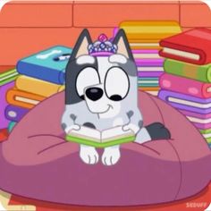 a cartoon dog sitting on top of a pillow with a book in it's lap