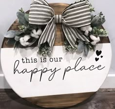 this is our happy place sign with cotton flowers and greenery on the front door