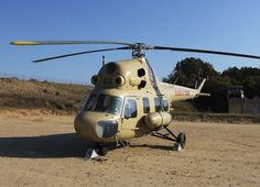 a helicopter sitting on top of a dirt field