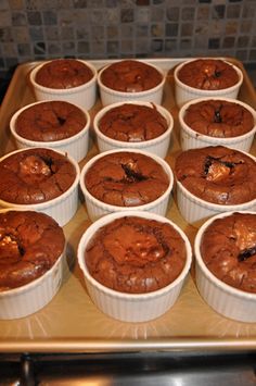 chocolate cupcakes in paper cups sitting on a baking tray ready to go into the oven