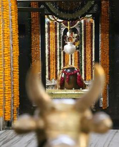 an ornate shrine decorated with flowers and gold bull horns is seen through the centerpieces