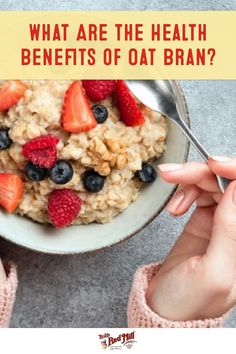 woman eating oatmeal with strawberries and blueberries in the bowl, text reads what are the health benefits of oat bran?