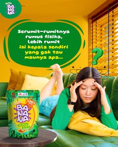 a woman laying on top of a green couch next to a box of baa vaya