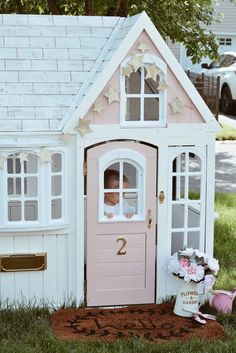 a pink doll house sitting in the grass