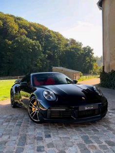 a black sports car parked in front of a house