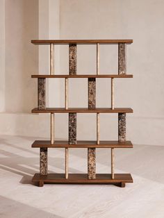 a wooden shelf with marbled shelves on it in an empty room next to a white wall