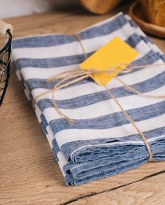 a stack of folded blue and white striped napkins with a yellow tag on top