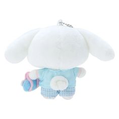 a white stuffed animal with blue and pink clothing on it's chest, hanging from a chain