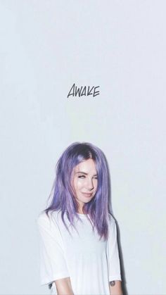 a young woman with purple hair standing in front of a white wall and the words awake above her head