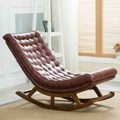 a brown leather rocking chair sitting on top of a carpeted floor next to a window