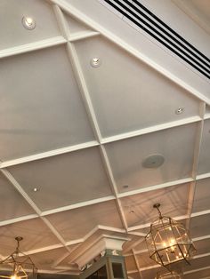 the ceiling is painted white and has chandeliers hanging from it