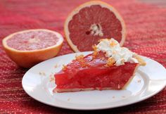 a piece of pie on a plate next to grapefruit