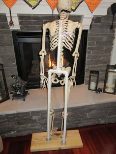 a skeleton is standing in front of a fireplace