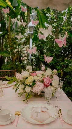 the table is set with pink and white flowers