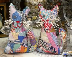 two stuffed animals sitting next to each other on top of a table covered in glassware