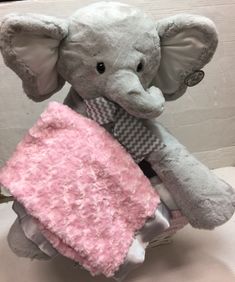 a stuffed elephant holding a pink blanket