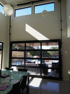 the sun shines through two large windows into a living room with sliding glass doors