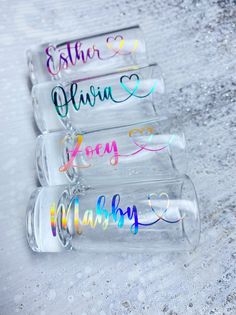 four personalized wine glasses sitting on top of a snow covered ground with the word love written in cursive writing